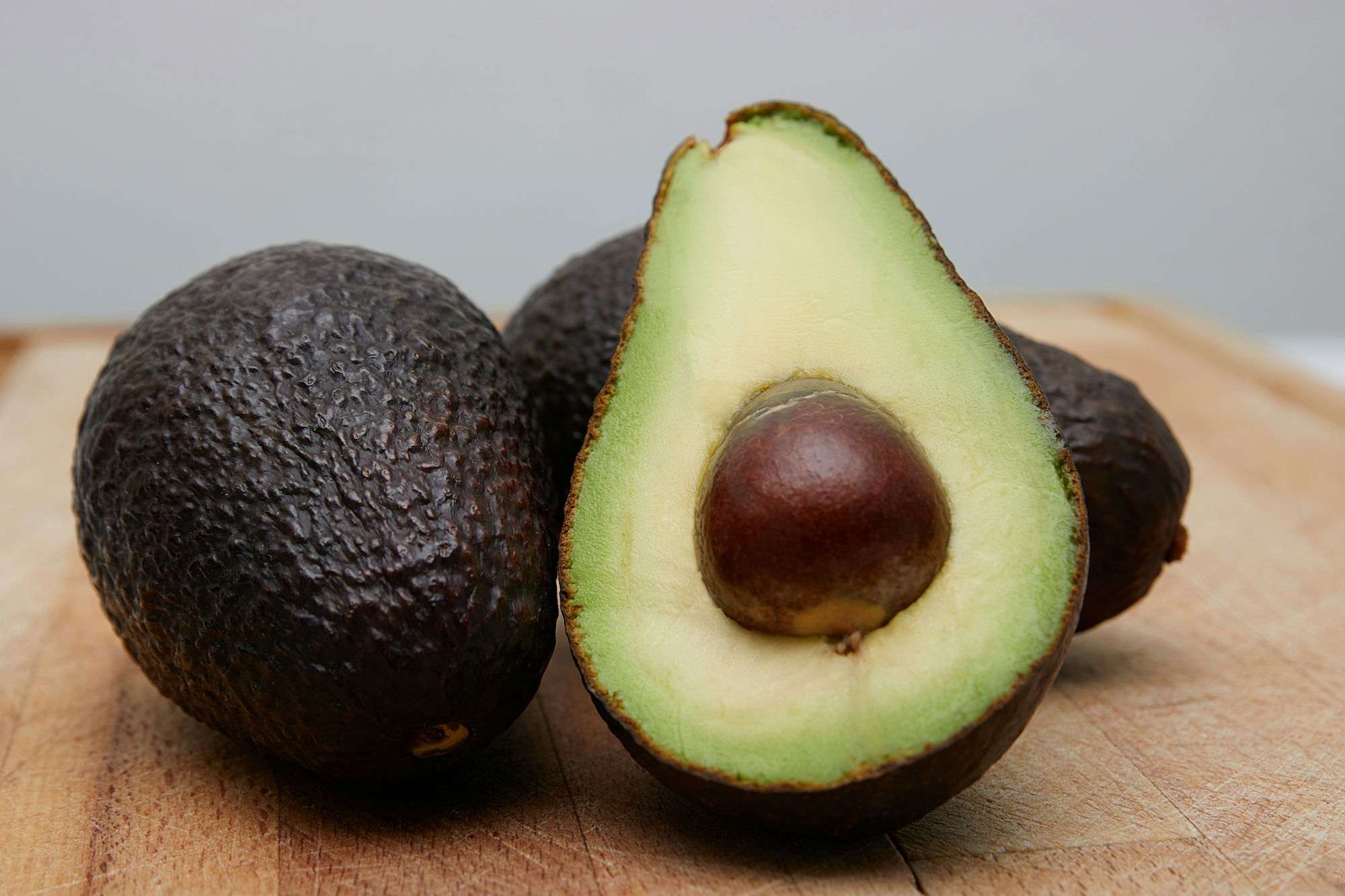 sliced-avocado-fruit-on-brown-wooden-table.jpg sliced avocado fruit on brown wooden table